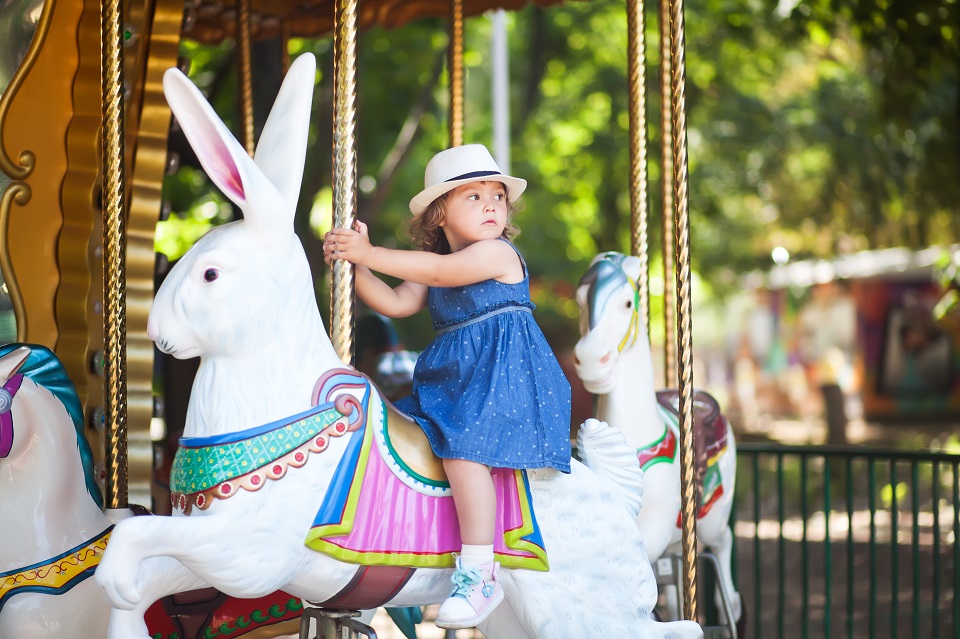 toddler kid riding vintage roundabout carousel